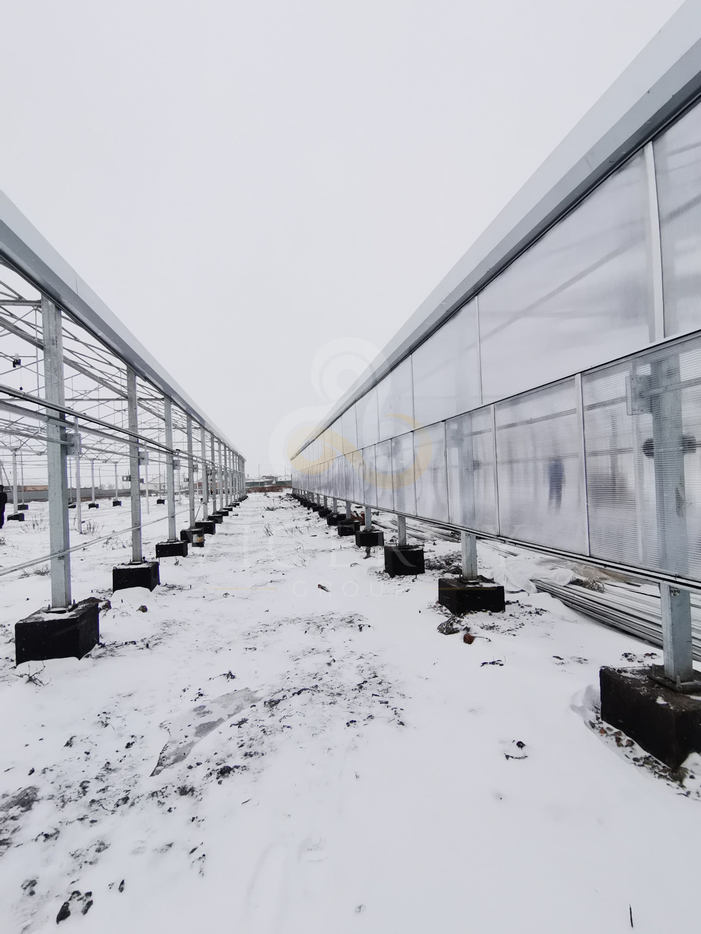 Perspective between the two greenhouse structures during construction